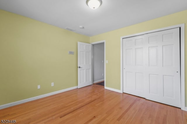 unfurnished bedroom featuring a closet and light hardwood / wood-style flooring