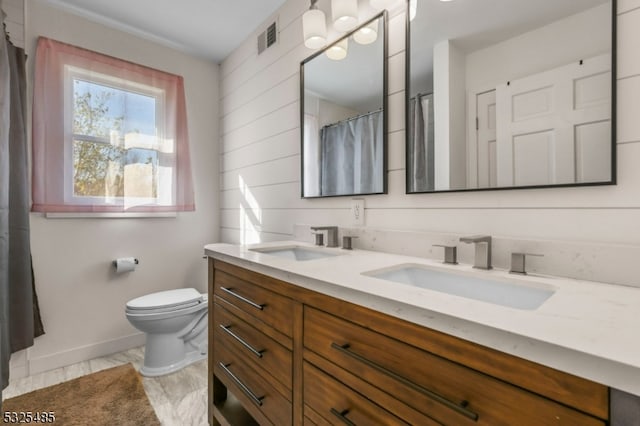 bathroom with vanity, curtained shower, and toilet