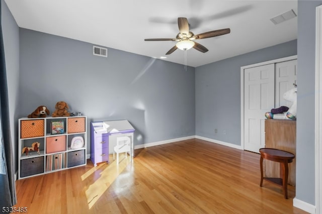 interior space featuring ceiling fan, a closet, and hardwood / wood-style flooring