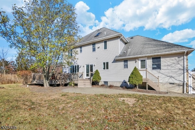 back of house featuring a deck and a lawn