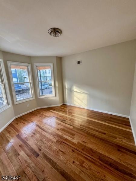 unfurnished room featuring hardwood / wood-style flooring