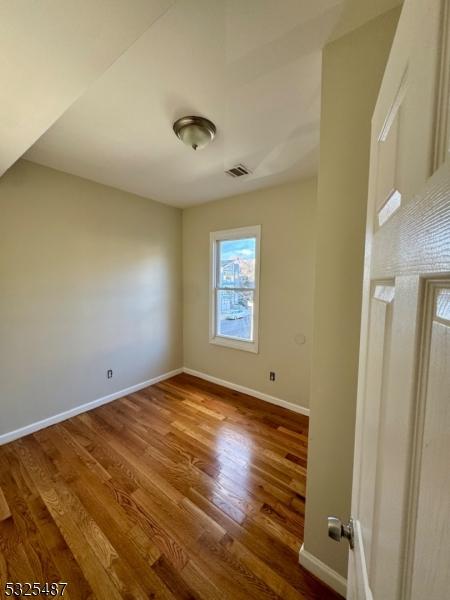 empty room with hardwood / wood-style flooring