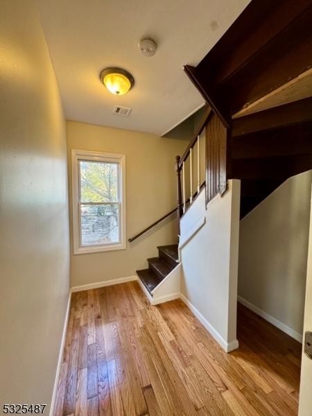 staircase with hardwood / wood-style flooring