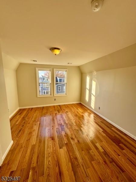 bonus room with hardwood / wood-style floors and lofted ceiling