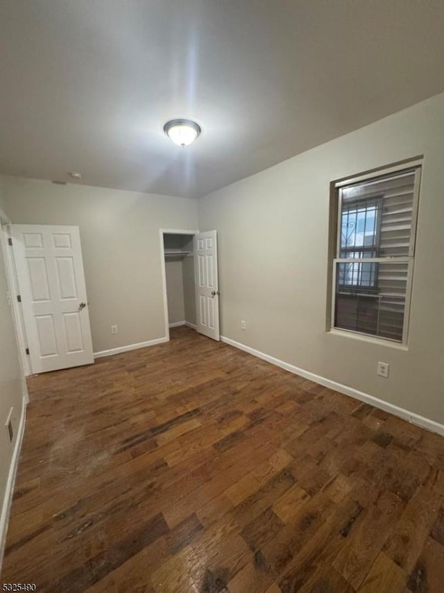 unfurnished bedroom with dark hardwood / wood-style flooring