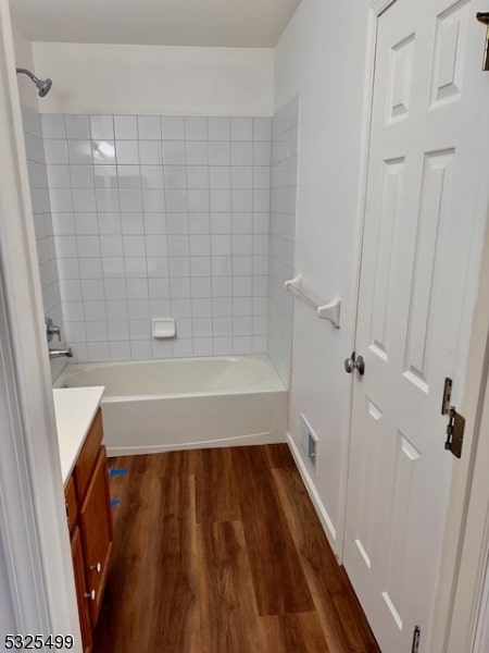 bathroom featuring hardwood / wood-style floors, vanity, and tiled shower / bath