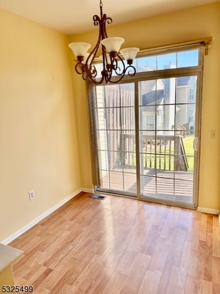 interior space featuring hardwood / wood-style floors and an inviting chandelier