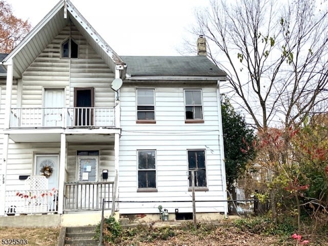 back of property with a balcony and covered porch