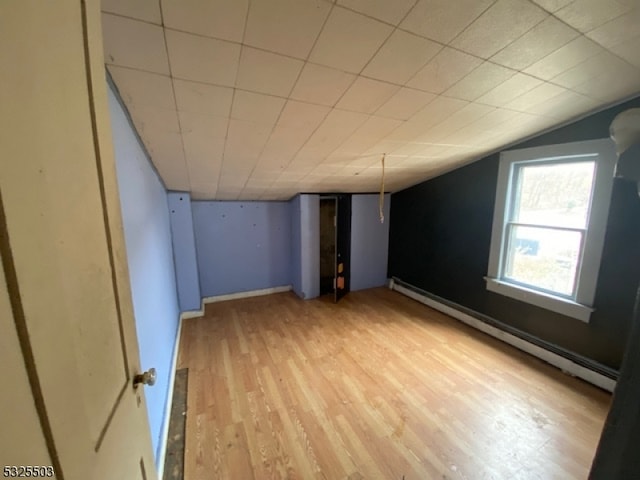 basement featuring hardwood / wood-style floors and baseboard heating