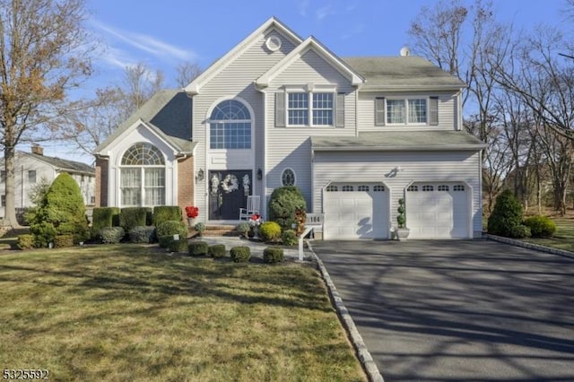 view of property featuring a garage and a front lawn