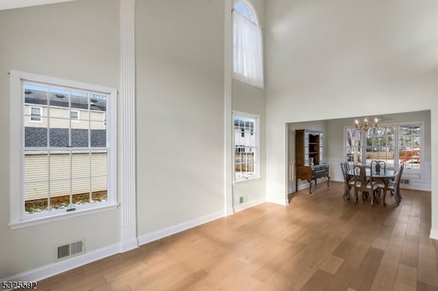 foyer with a chandelier, a towering ceiling, and hardwood / wood-style flooring