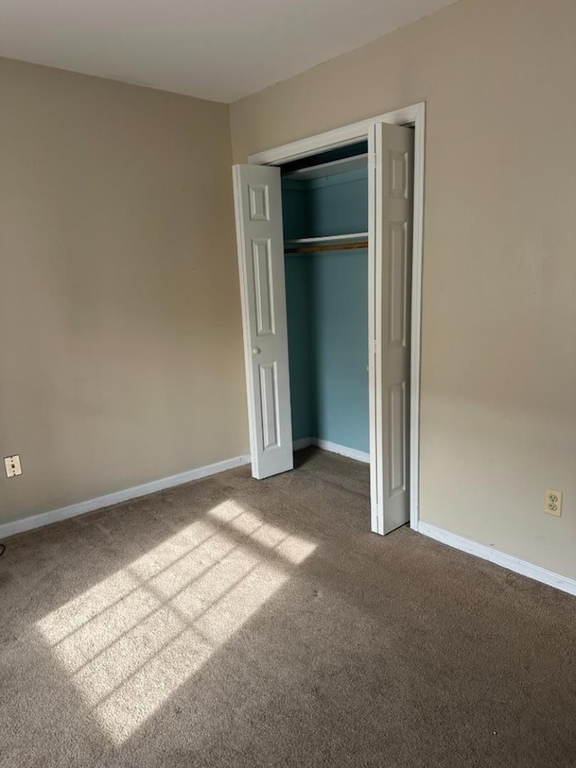 unfurnished bedroom with carpet flooring and a closet