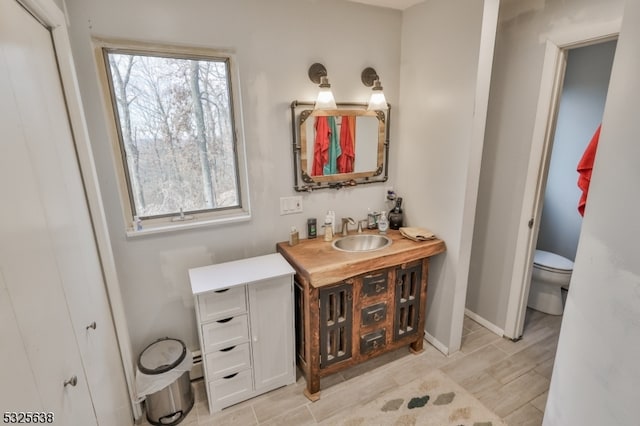 bathroom featuring wood-type flooring, vanity, and toilet