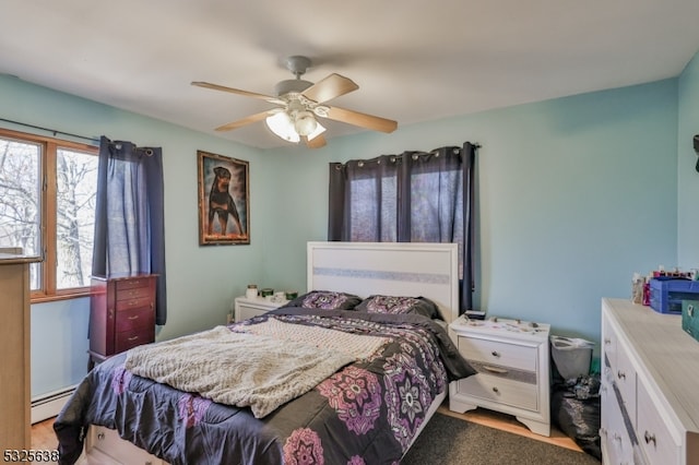 bedroom with ceiling fan and baseboard heating