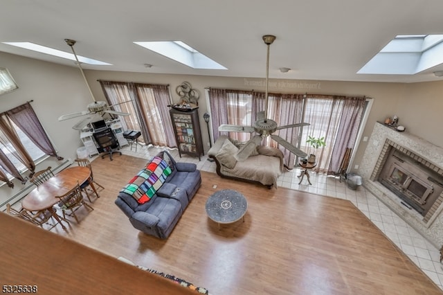 living room featuring ceiling fan, a fireplace, and hardwood / wood-style floors