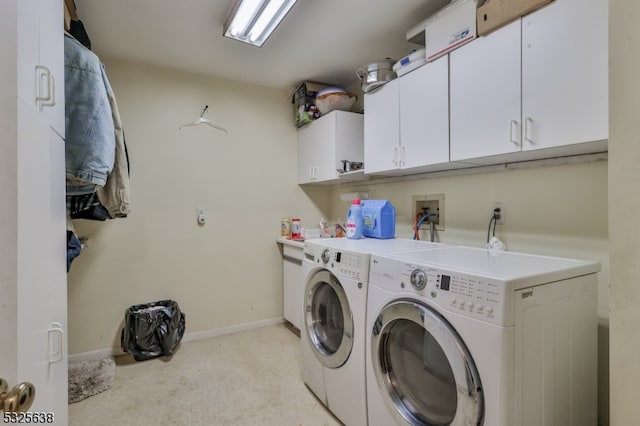 washroom with washer and clothes dryer, cabinets, and light carpet