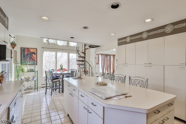 kitchen featuring white cabinets, a center island, light tile patterned floors, and white dishwasher