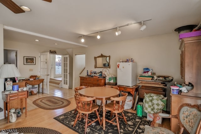 dining space featuring french doors, light wood-type flooring, and track lighting