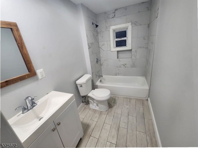 full bathroom with tiled shower / bath, vanity, and toilet