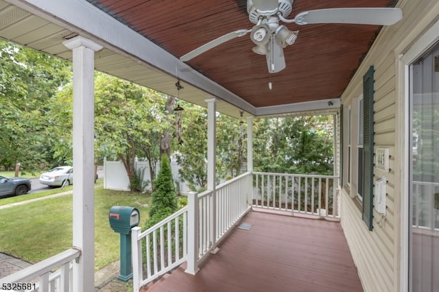 deck with a lawn, ceiling fan, and covered porch