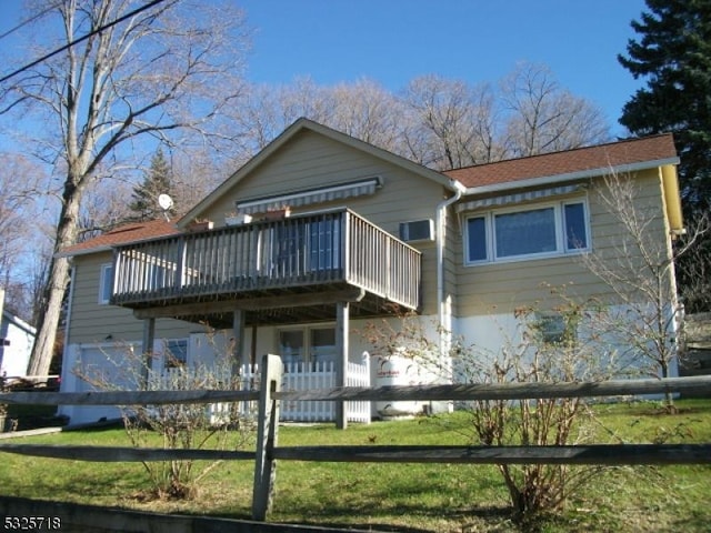 rear view of house with a deck and a yard