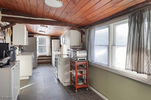 kitchen with electric range, dark tile patterned floors, and white cabinets