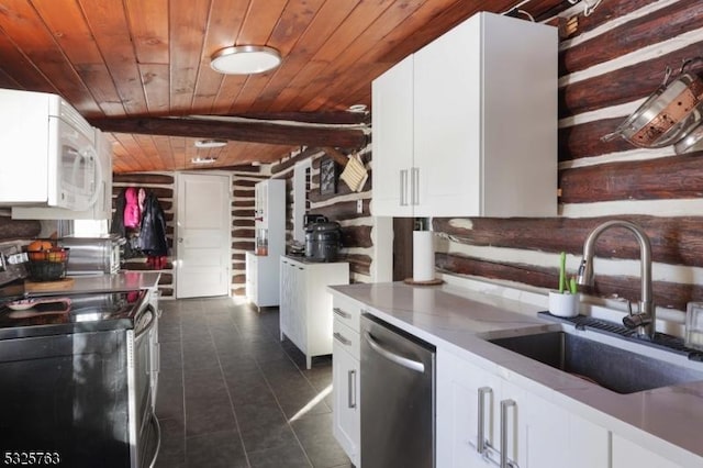 kitchen featuring stainless steel appliances, dark tile patterned flooring, a sink, wood ceiling, and white cabinetry