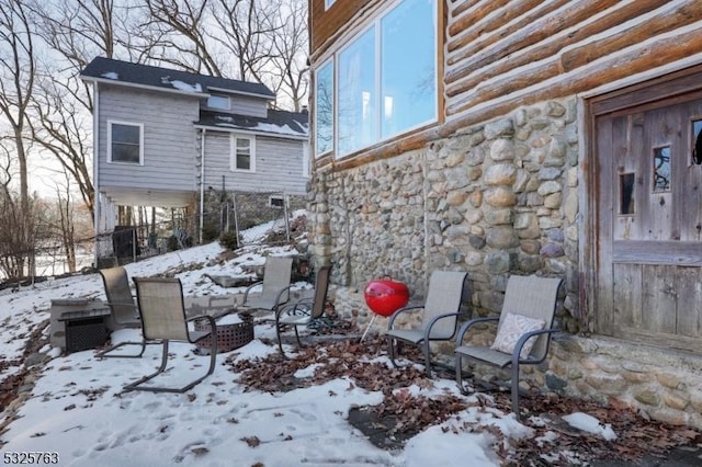 snow covered patio with a fire pit