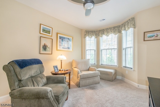 living area featuring ceiling fan and carpet