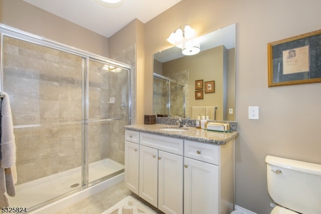 bathroom with toilet, vanity, tile patterned floors, and an enclosed shower