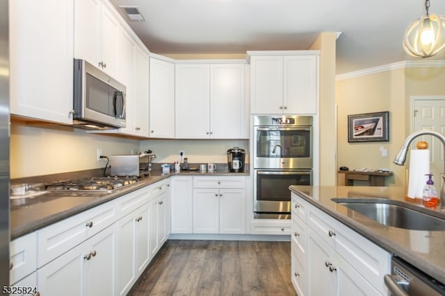 kitchen with white cabinets, crown molding, sink, dark hardwood / wood-style floors, and stainless steel appliances