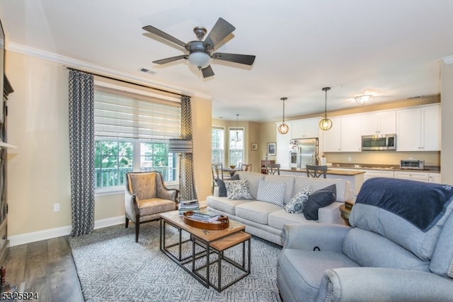 living room featuring hardwood / wood-style flooring, ceiling fan, and crown molding