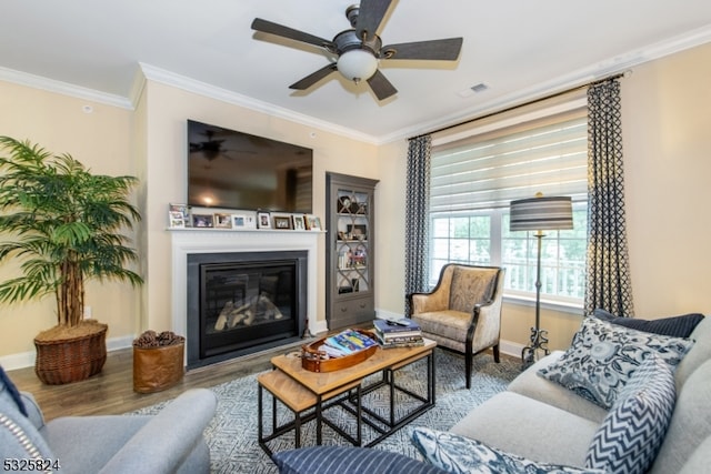 living room with crown molding, ceiling fan, and wood-type flooring