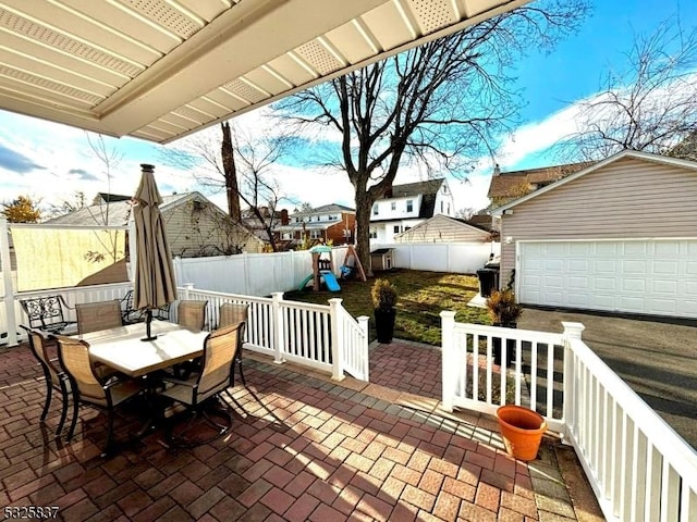 view of patio / terrace with an outbuilding, a playground, and a garage