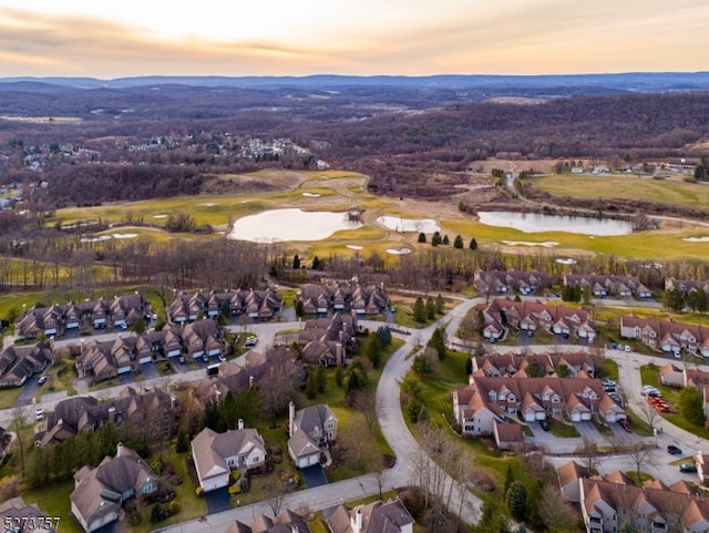 aerial view at dusk featuring a water view