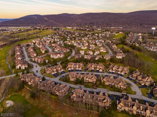 aerial view at dusk featuring a mountain view