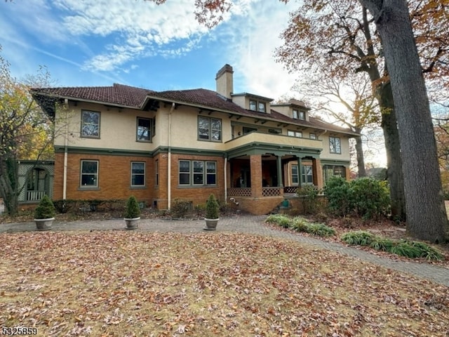 rear view of property featuring covered porch