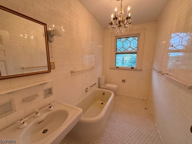 bathroom with sink, a bath, tile patterned floors, toilet, and tile walls