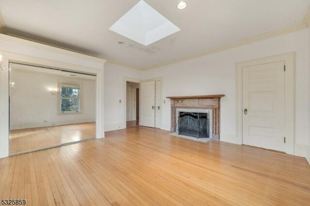 26 Ridge Rd, Summit City, NJ 07901 - unfurnished living room featuring light wood-style flooring, a fireplace with flush hearth, a skylight, ornamental molding, and recessed lighting