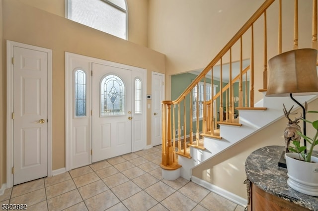 entryway with light tile patterned floors and a high ceiling