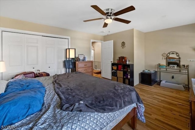 bedroom with hardwood / wood-style floors, ceiling fan, and a closet