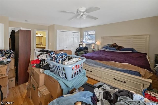 bedroom featuring ensuite bath, ceiling fan, a closet, and light wood-type flooring