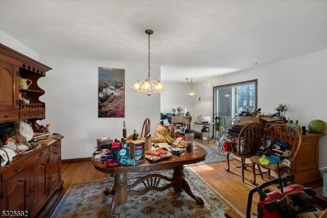 dining space with light hardwood / wood-style flooring and a notable chandelier