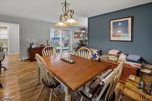 dining area featuring light hardwood / wood-style floors and a baseboard heating unit