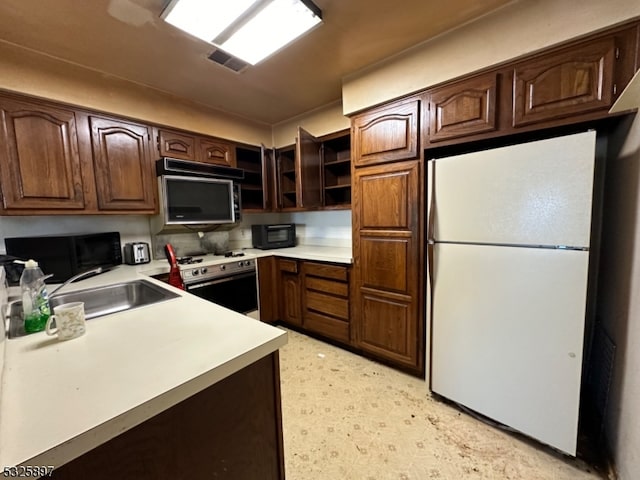 kitchen with dark brown cabinetry, sink, and white appliances