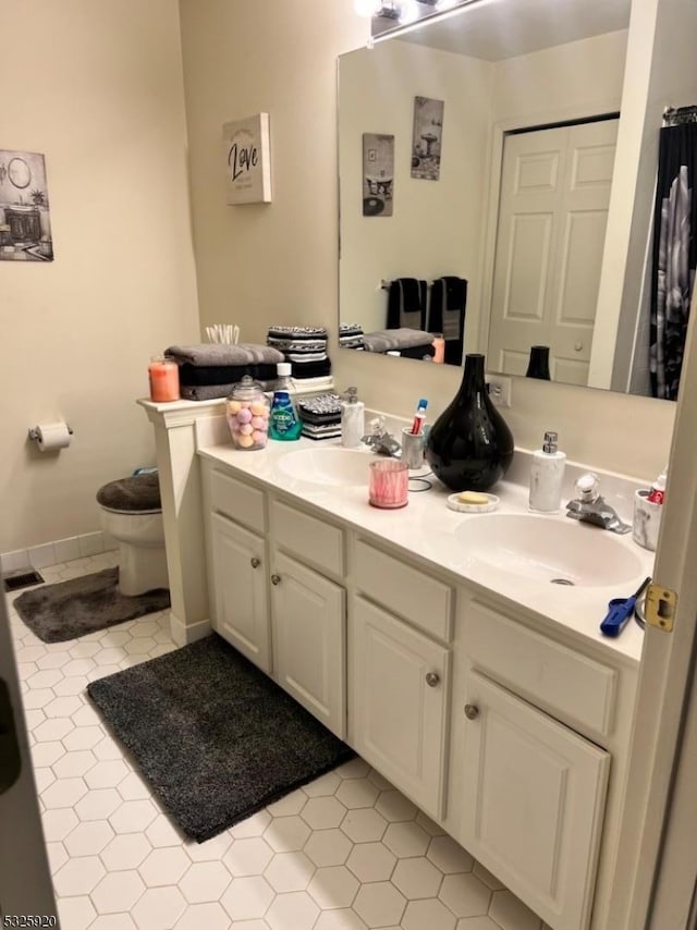 bathroom featuring tile patterned flooring, vanity, and toilet