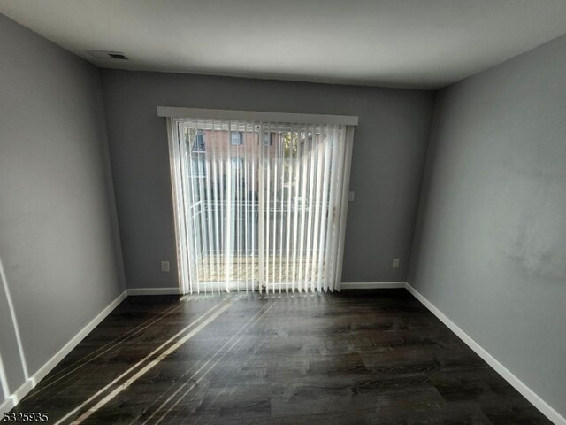 unfurnished room featuring dark wood-type flooring