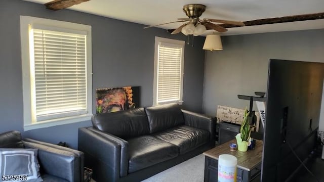 living room with ceiling fan and beam ceiling