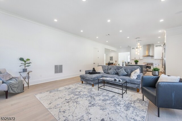 living room featuring ornamental molding and light hardwood / wood-style floors