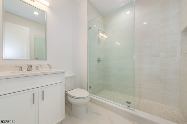 bathroom featuring vanity, toilet, and a shower with shower door